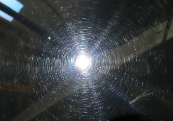 Close-up of vehicle paint under direct light showing fine swirl marks before correction