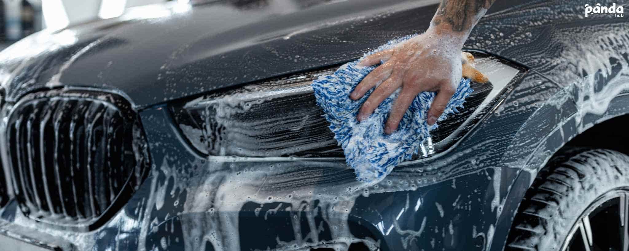 Technician hand washing a vehicle's exterior panel