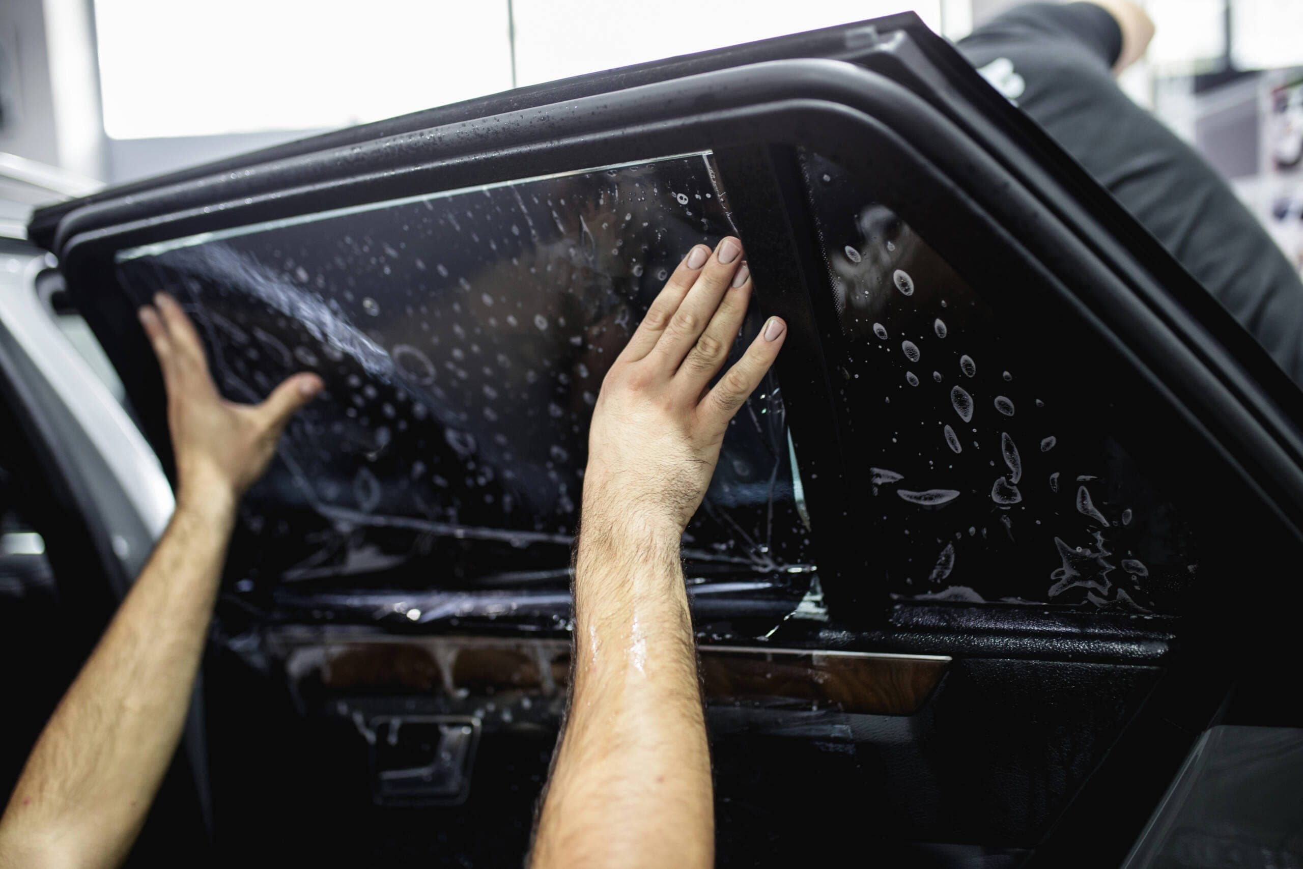 Close-up of freshly installed window tint film on a rear vehicle window